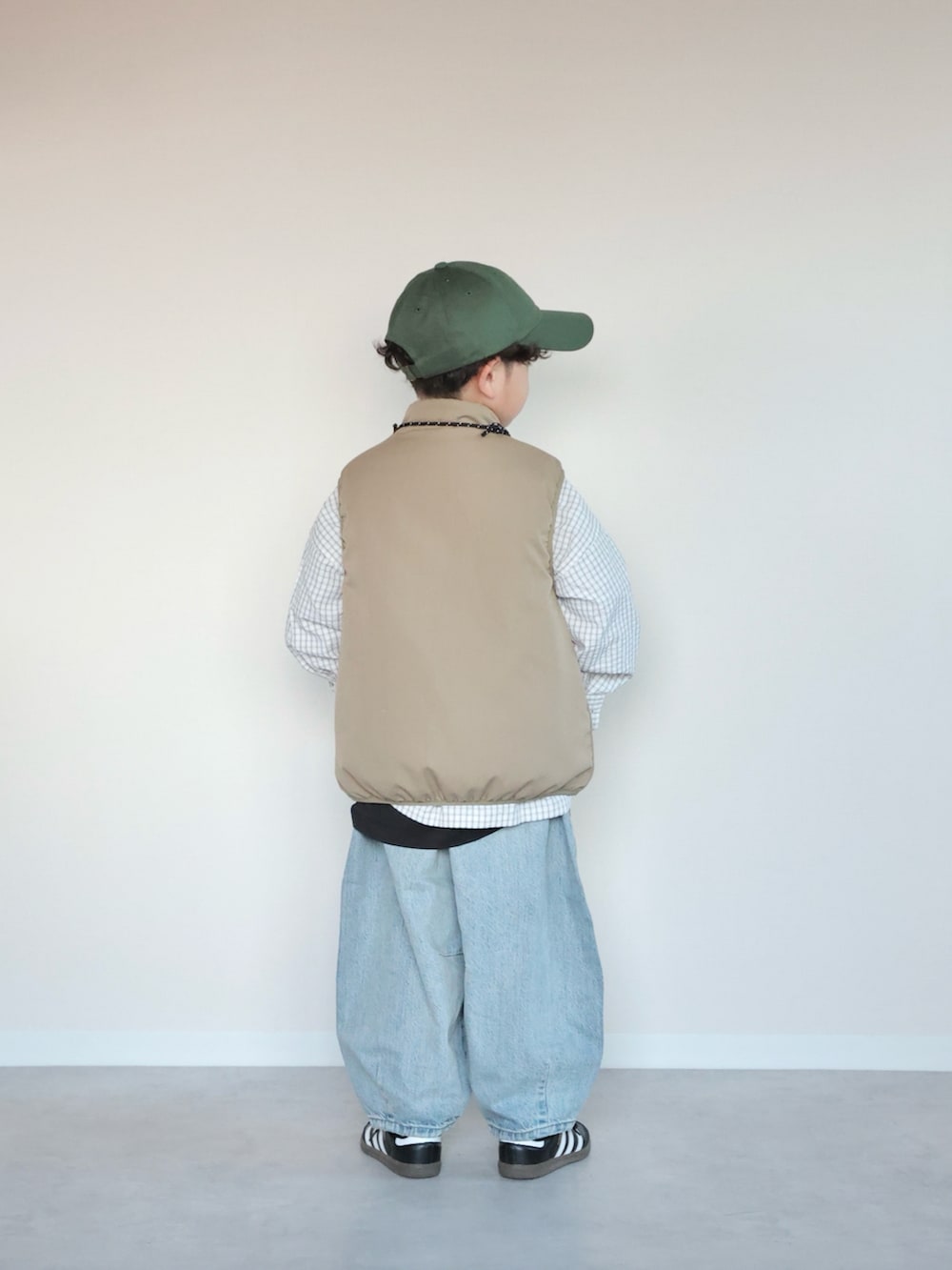 ベージュ系のベスト、ホワイト系のシャツ/ブラウス、ブルー系のデニムパンツを着用したキッズの春コーディネートの3枚目の写真