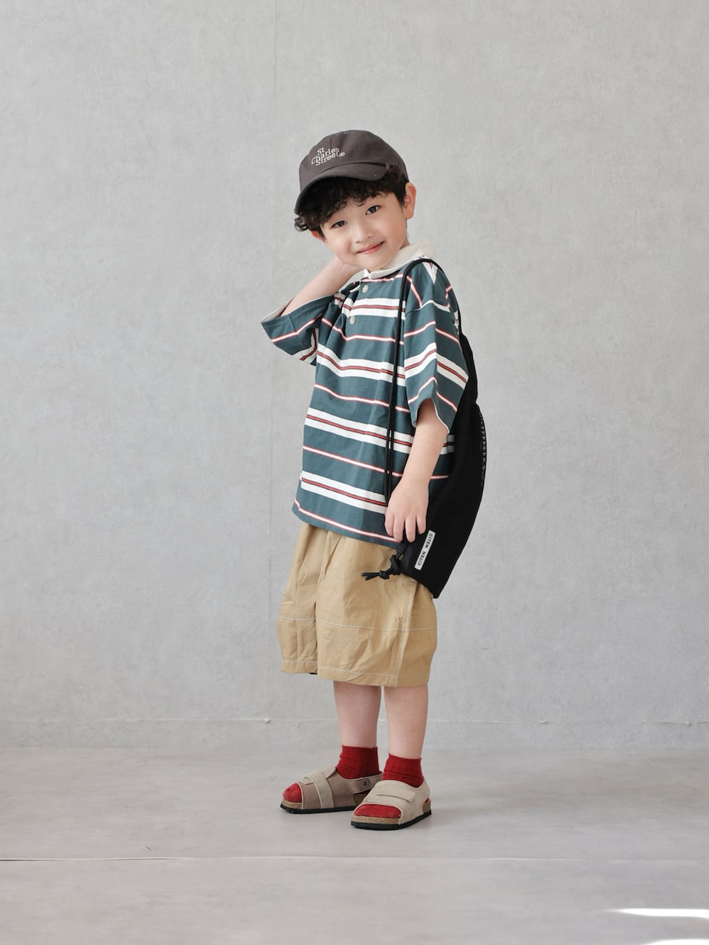 グリーン系のポロシャツ、ベージュ系のその他パンツ、ベージュ系のサンダルを着用したキッズの春コーディネートの2枚目の写真
