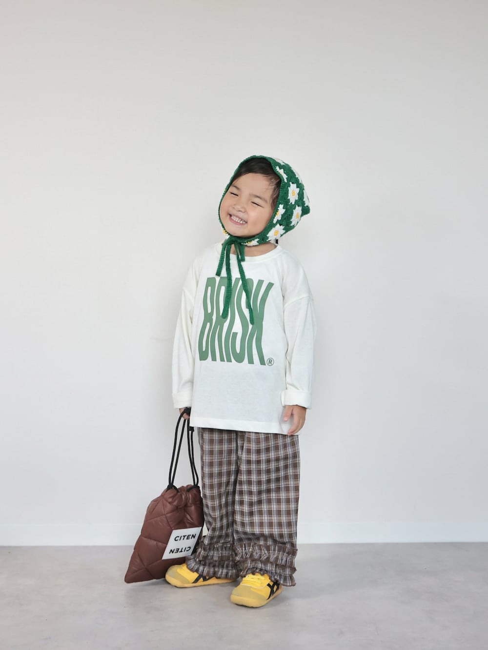 ホワイト系のTシャツ/カットソー、ブラウン系のその他パンツ、ブラウン系のショルダーバッグを着用したキッズの秋コーディネートの2枚目の写真