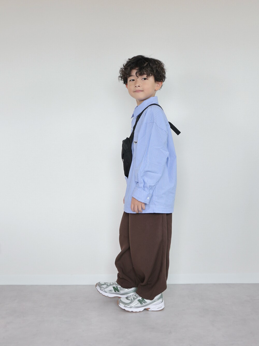 ブルー系のシャツ/ブラウス、ブラウン系のその他パンツ、グレー系のスニーカーを着用したキッズの秋コーディネートの3枚目の写真