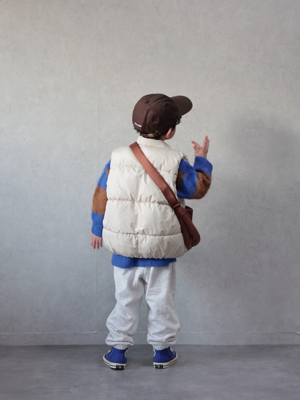 ホワイト系のベスト、ブルー系のニット/セーター、ベージュ系のその他パンツを着用したキッズの冬コーディネートの3枚目の写真