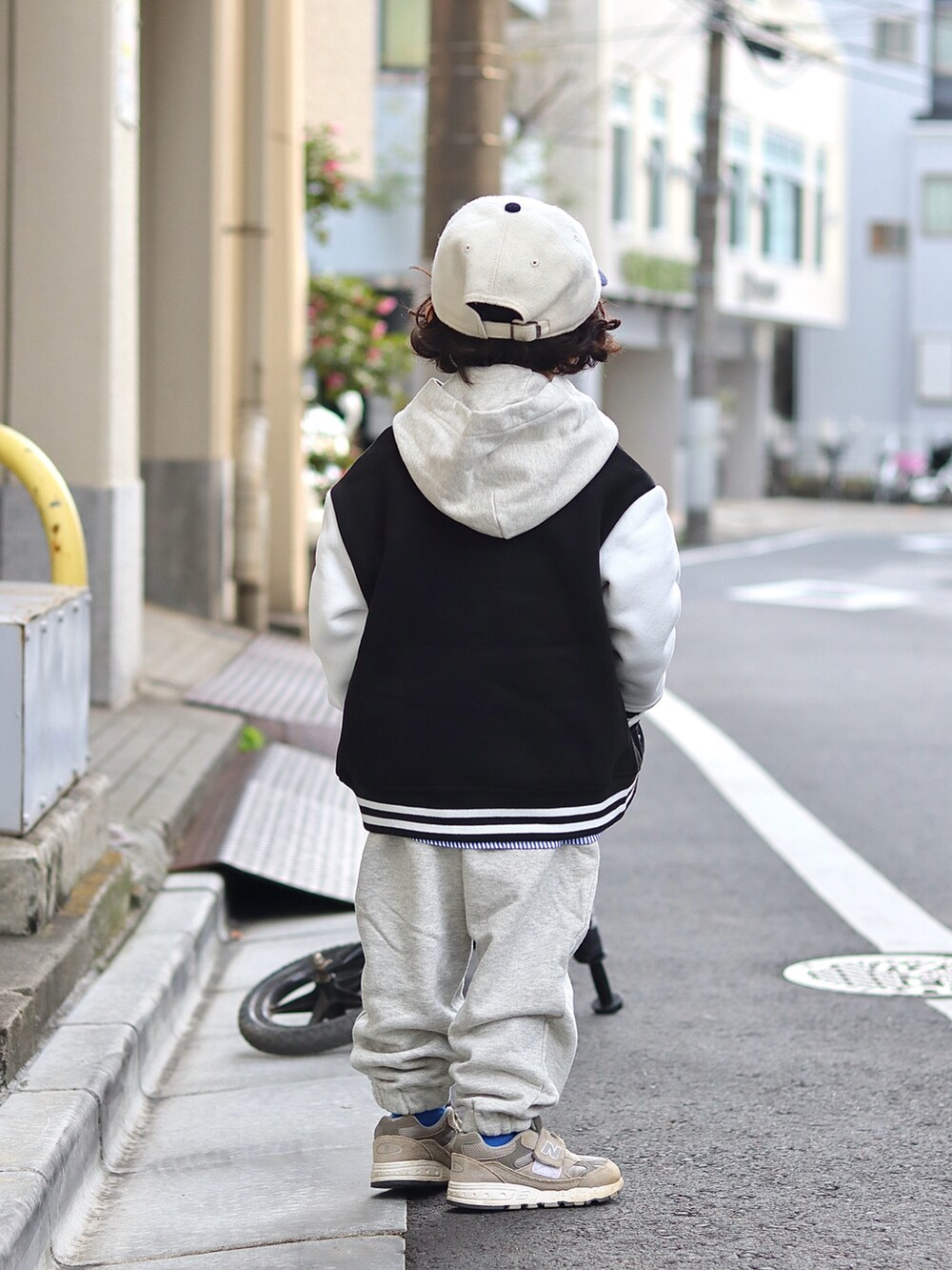 ブラック系のスタジャン、ホワイト系のパーカー、ホワイト系のスウェットパンツを着用したキッズの冬コーディネートの3枚目の写真