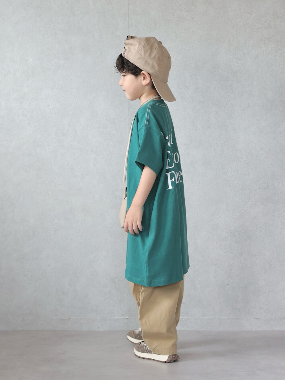 グリーン系のワンピース、ベージュ系のカーゴパンツ、ブラウン系のスニーカーを着用したキッズの夏コーディネートの4枚目の写真