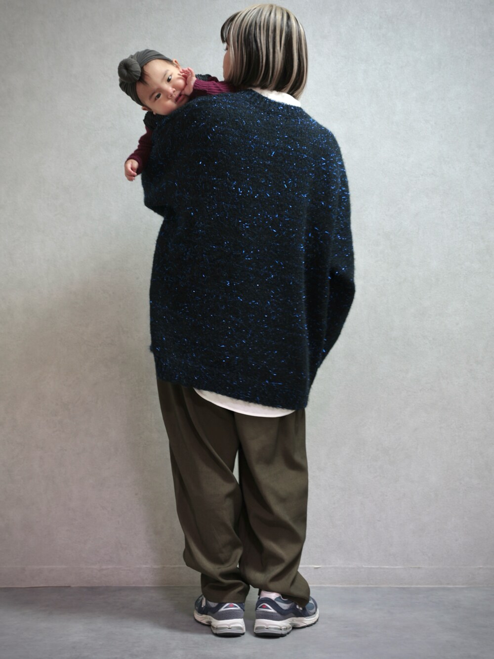 ブラック系のニット/セーター、グリーン系のスラックス、ブルー系のスニーカーを着用したキッズの冬コーディネートの3枚目の写真