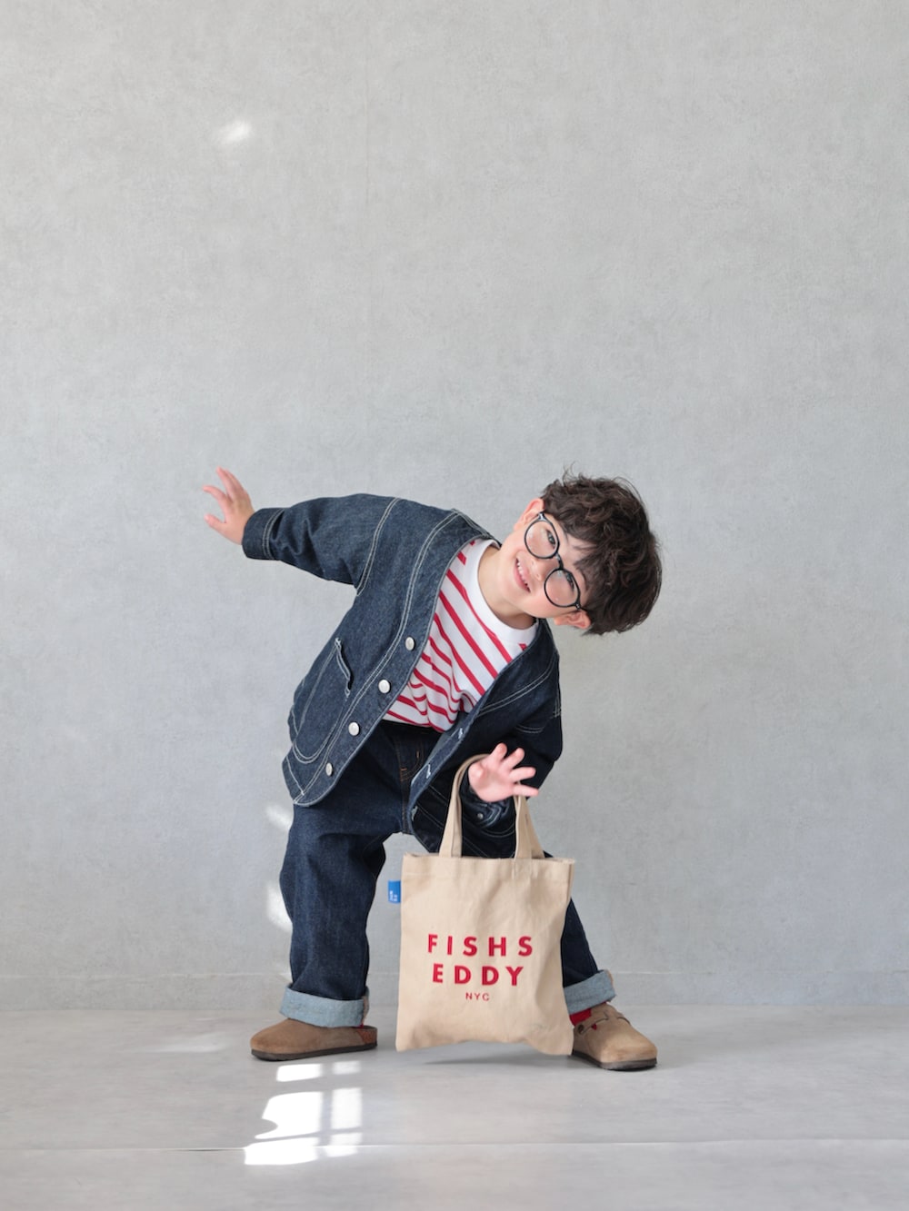 ブルー系のカバーオール、レッド系のTシャツ/カットソー、ブルー系のデニムパンツを着用したキッズの春コーディネートの4枚目の写真