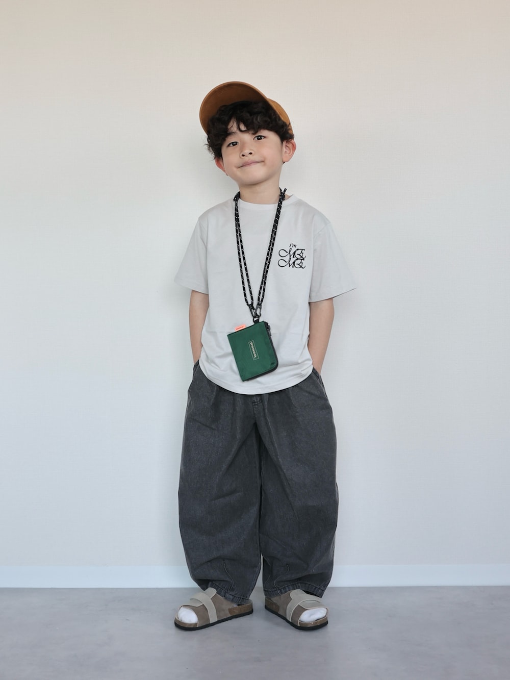 グレー系のTシャツ/カットソー、ブラック系のデニムパンツ、ベージュ系のサンダルを着用したキッズの春コーディネートの3枚目の写真