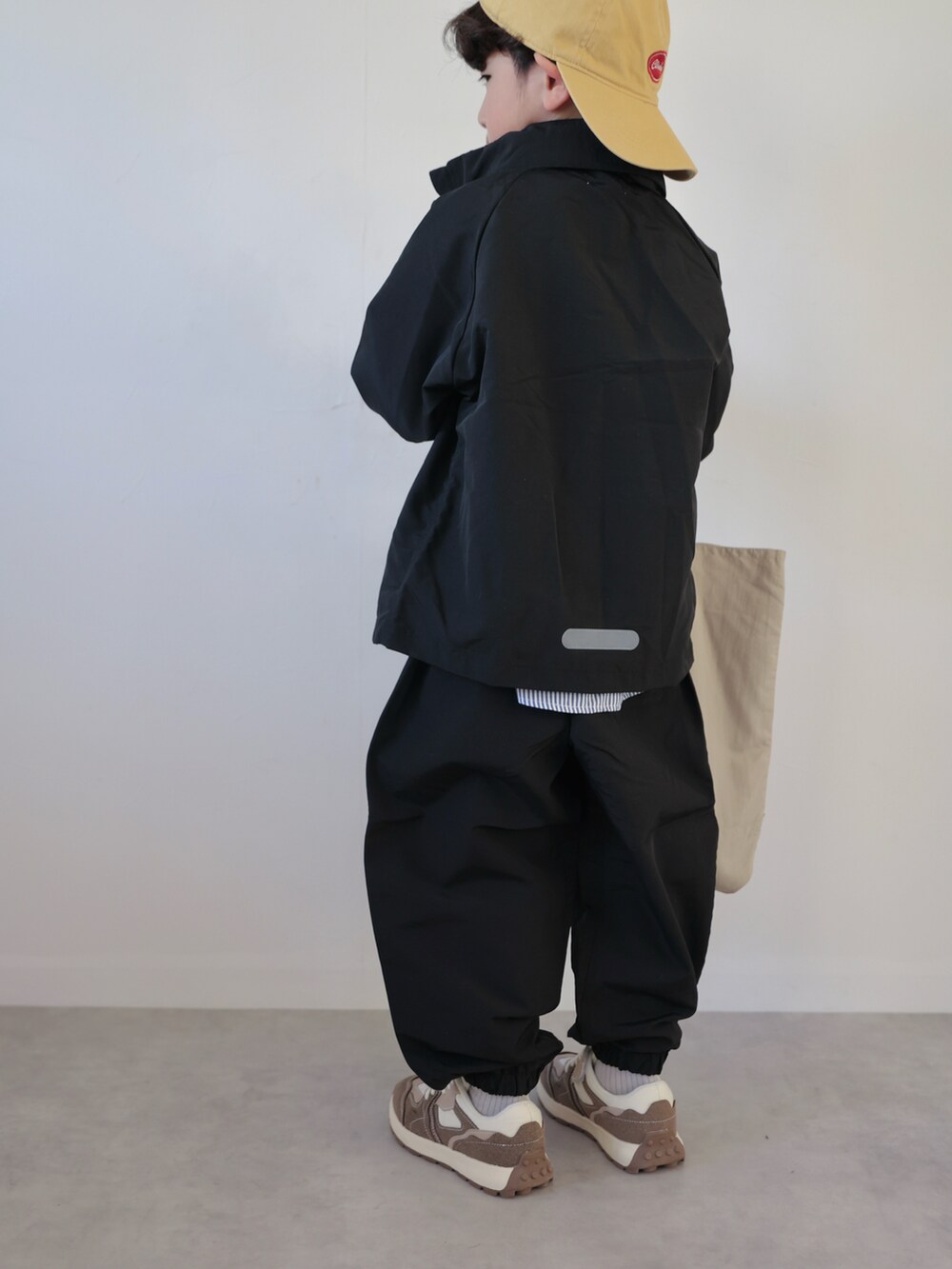 ブラック系のマウンテンパーカー、ブラック系のその他パンツ、グレー系のスウェットを着用したキッズの冬コーディネートの5枚目の写真