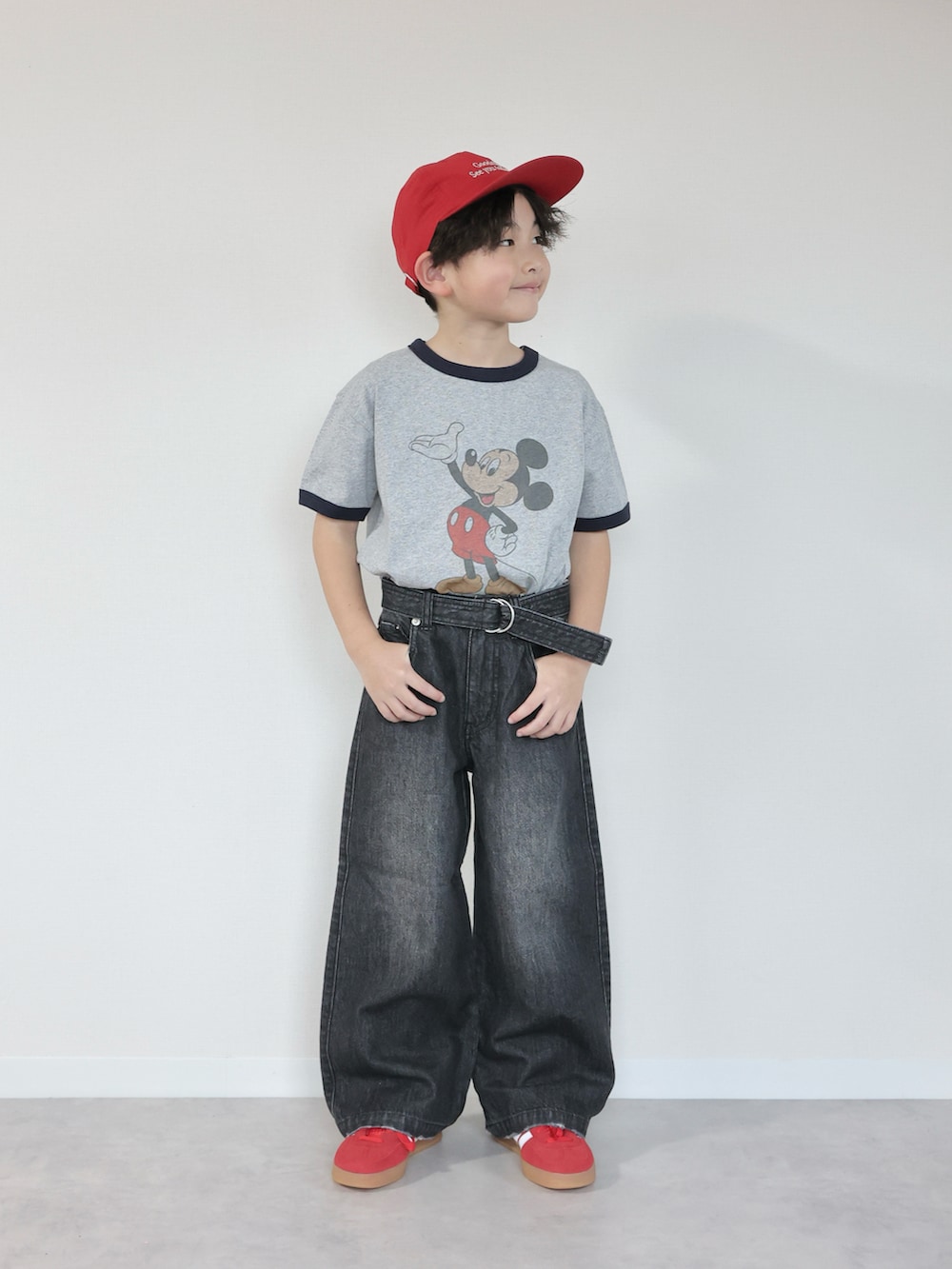 グレー系のTシャツ/カットソー、ブラック系のデニムパンツ、ホワイト系のショルダーバッグを着用したキッズの冬コーディネートの5枚目の写真