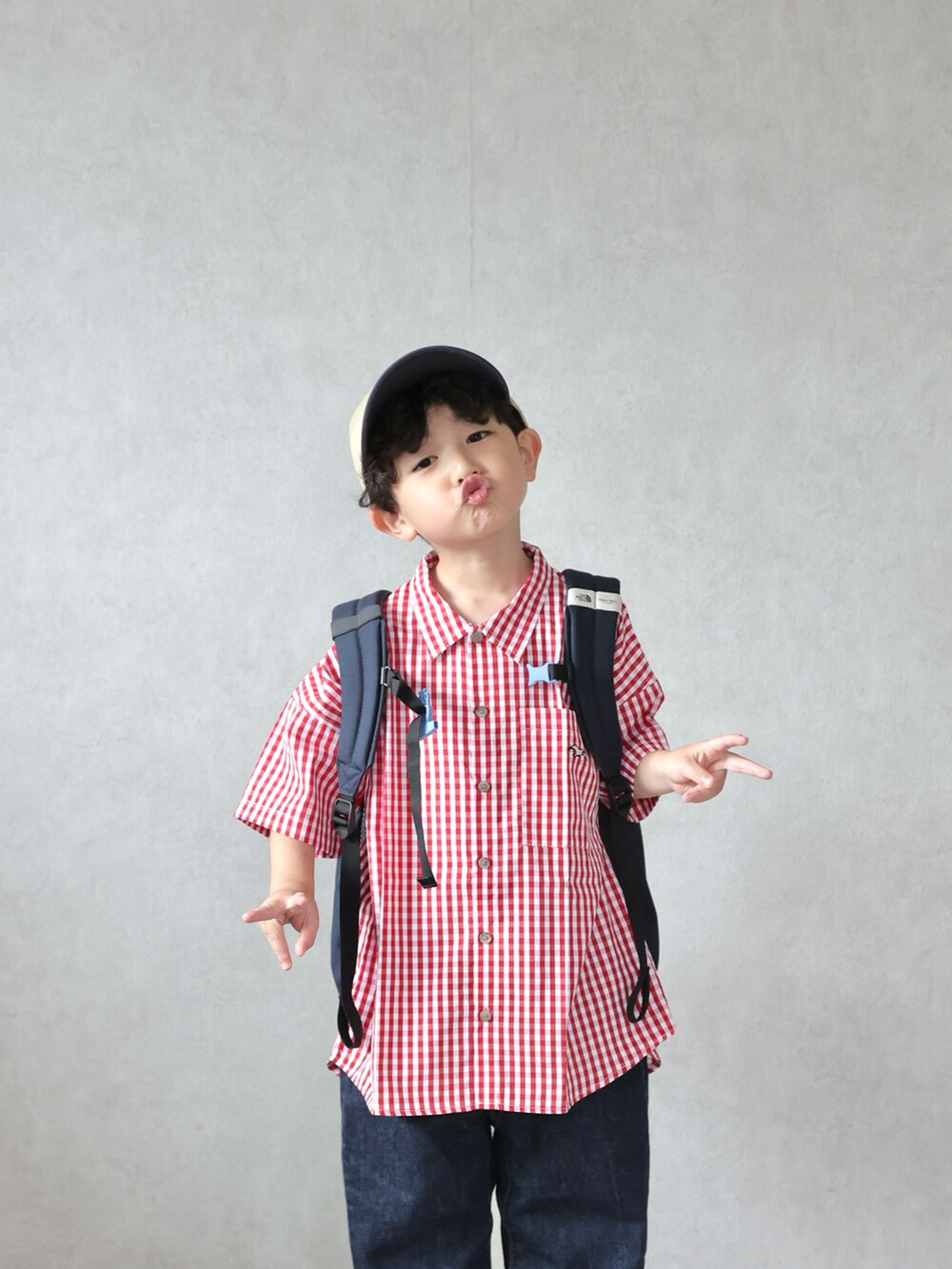 レッド系のシャツ/ブラウス、ブルー系のデニムパンツ、ホワイト系のスニーカーを着用したキッズの春コーディネートの4枚目の写真