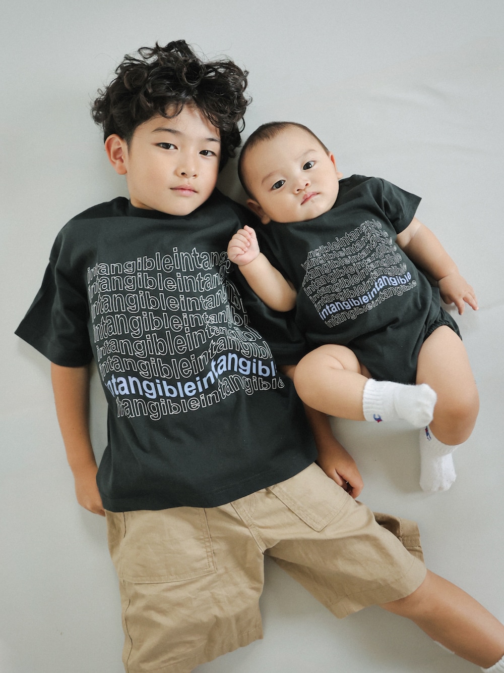 ブラック系のTシャツ/カットソー、グレー系のスニーカー、ベージュ系のパンツを着用したキッズの夏コーディネートの2枚目の写真