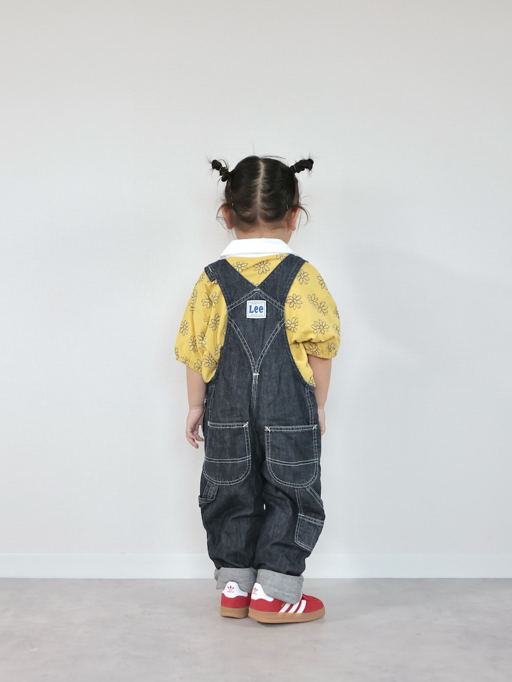 レッド系のスニーカー、イエロー系のTシャツ/カットソー、ブルー系のサロペット/オーバーオールを着用したキッズの夏コーディネートの3枚目の写真