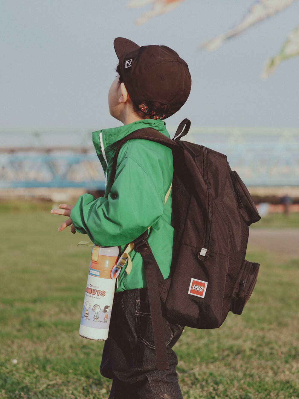 グリーン系のブルゾン、ブルー系のデニムパンツ、グリーン系のスニーカーを着用したキッズの春コーディネートの4枚目の写真