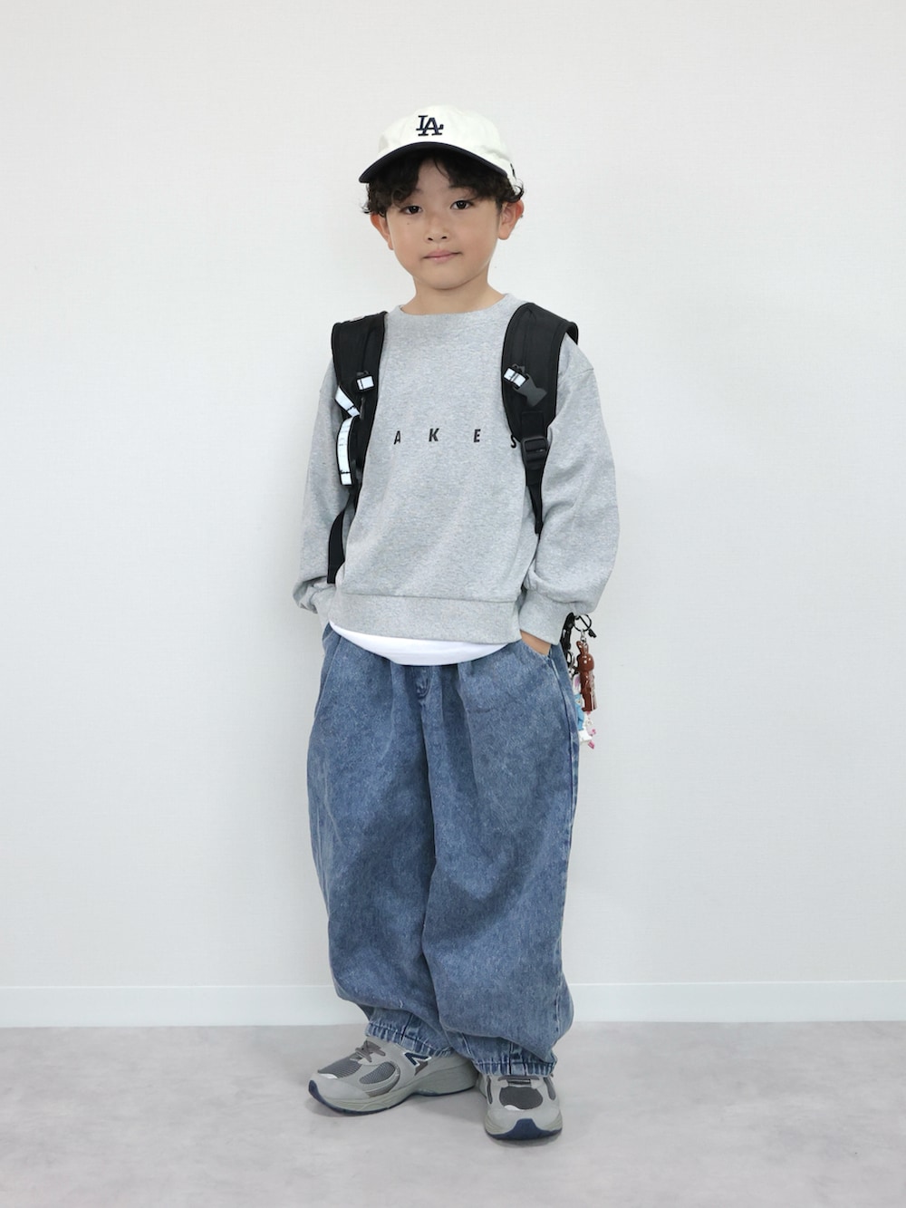 グレー系のTシャツ/カットソー、ブルー系のデニムパンツ、グレー系のスニーカーを着用したキッズの秋コーディネートの5枚目の写真
