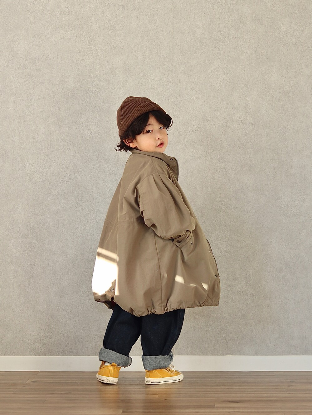 グリーン系のモッズコート、ブルー系のスウェット、ブルー系のデニムパンツを着用したキッズの冬コーディネートの4枚目の写真