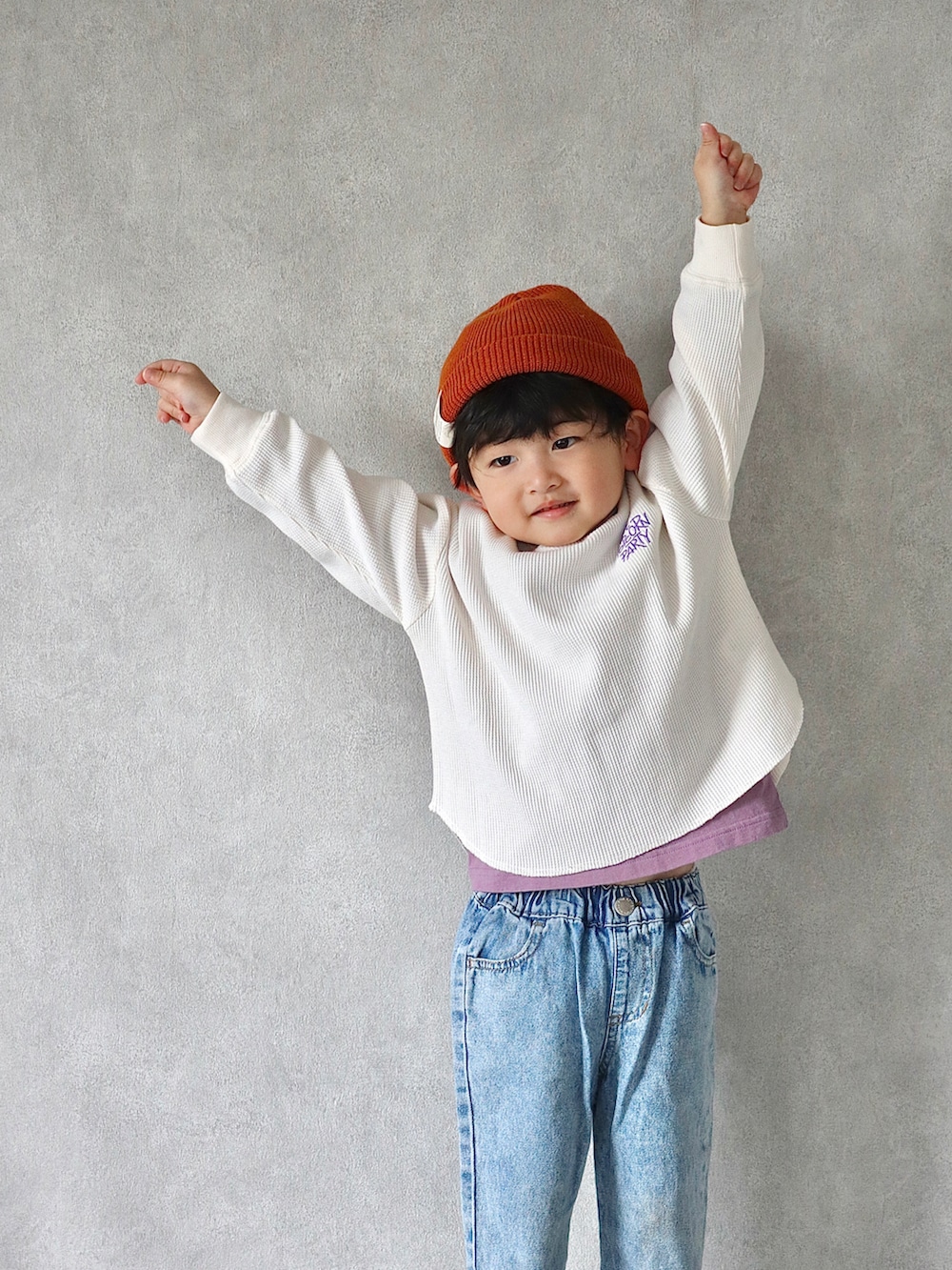 ホワイト系のTシャツ/カットソー、ブルー系のデニムパンツ、ブラック系のスニーカーを着用したキッズの冬コーディネートの2枚目の写真