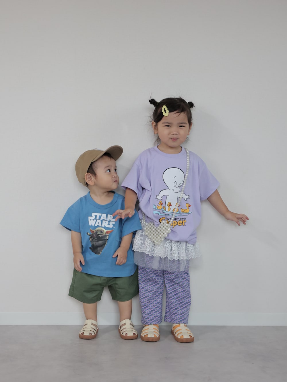 ブルー系のセットアップ、パープル系のTシャツ/カットソー、ベージュ系のサンダルを着用したキッズの夏コーディネートの3枚目の写真
