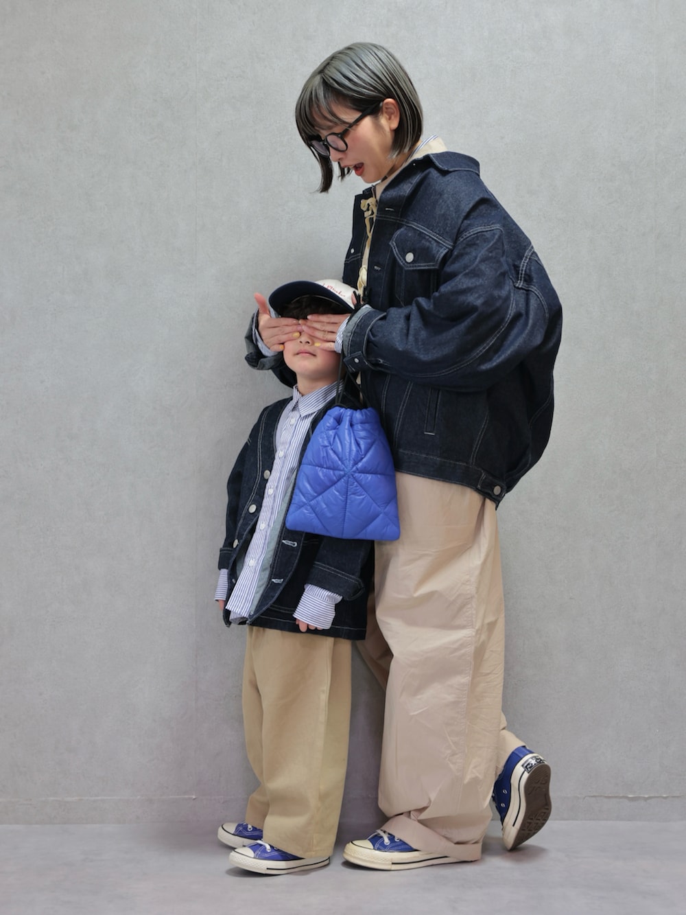 ベージュ系のつなぎ/オールインワン、ブルー系のショルダーバッグ、ブルー系のカバーオールを着用したキッズの冬コーディネートの2枚目の写真