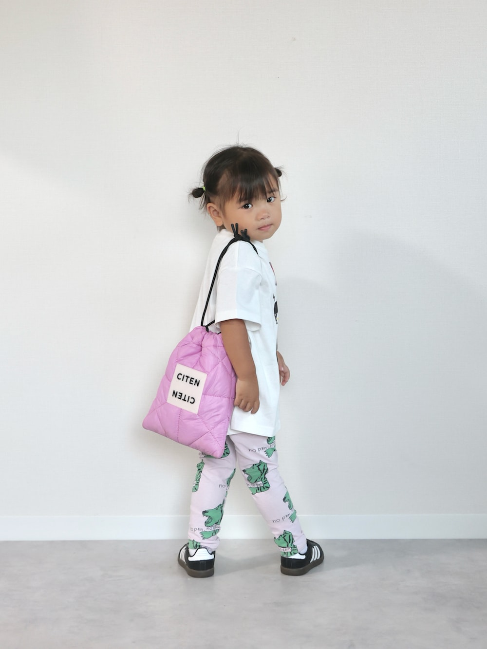 ブラック系のスニーカー、ホワイト系のTシャツ/カットソー、ピンク系のショルダーバッグを着用したキッズの夏コーディネートの4枚目の写真