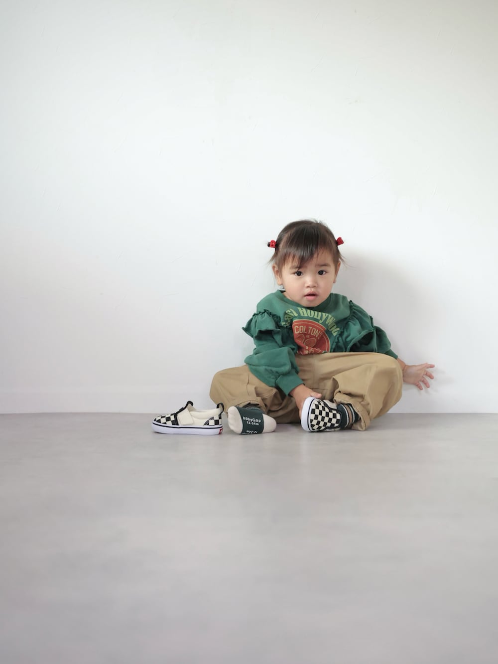 グリーン系のスウェット、ベージュ系のその他パンツ、ブラック系のスニーカーを着用したキッズの冬コーディネートの5枚目の写真