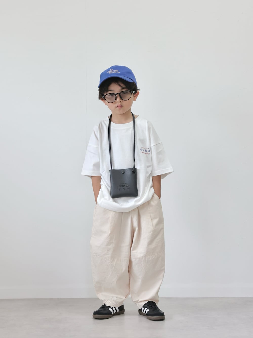 ホワイト系のTシャツ/カットソー、ホワイト系のその他パンツ、ブラック系のスニーカーを着用したキッズの夏コーディネートの4枚目の写真