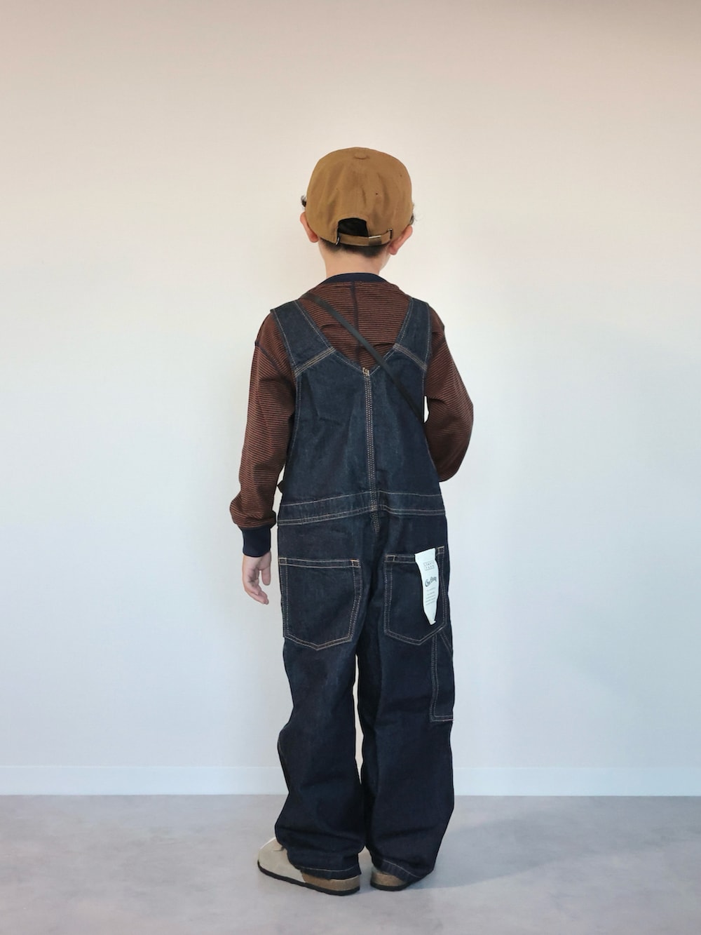 ブルー系のサロペット/オーバーオール、ベージュ系のサンダル、ブラウン系のTシャツ/カットソーを着用したキッズの夏コーディネートの2枚目の写真