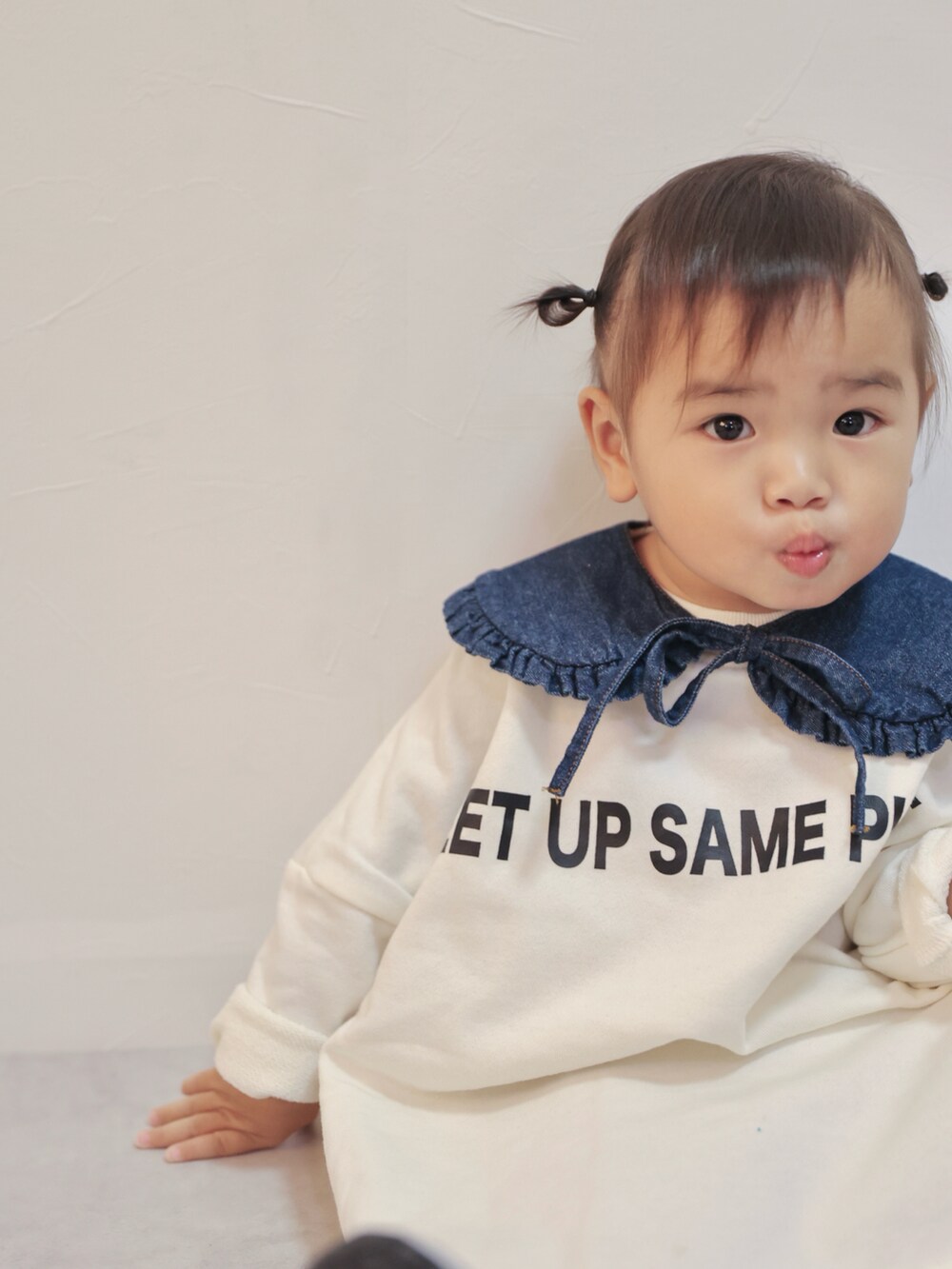 ホワイト系のワンピース、グレー系のスニーカー、ブルー系の付け襟を着用したキッズの秋コーディネートの3枚目の写真