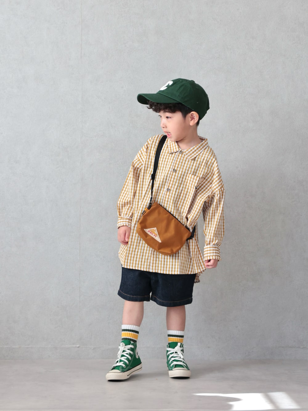 イエロー系のシャツ/ブラウス、ブルー系のデニムパンツ、グリーン系のスニーカーを着用したキッズの春コーディネートの3枚目の写真