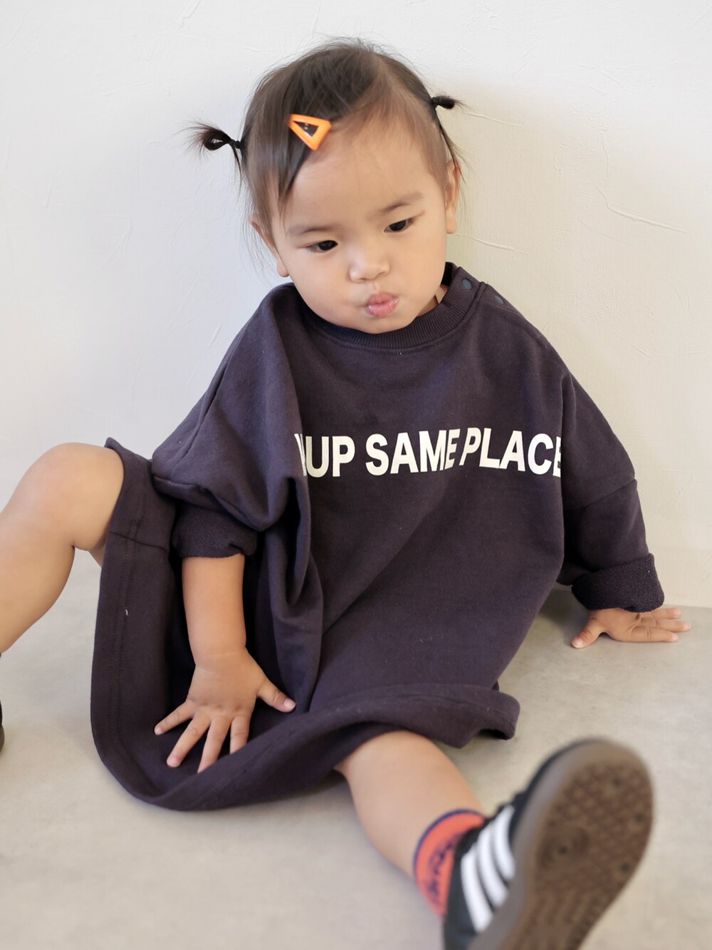 ブルー系のワンピース、オレンジ系のショルダーバッグ、ブラック系のスニーカーを着用したキッズの秋コーディネートの3枚目の写真