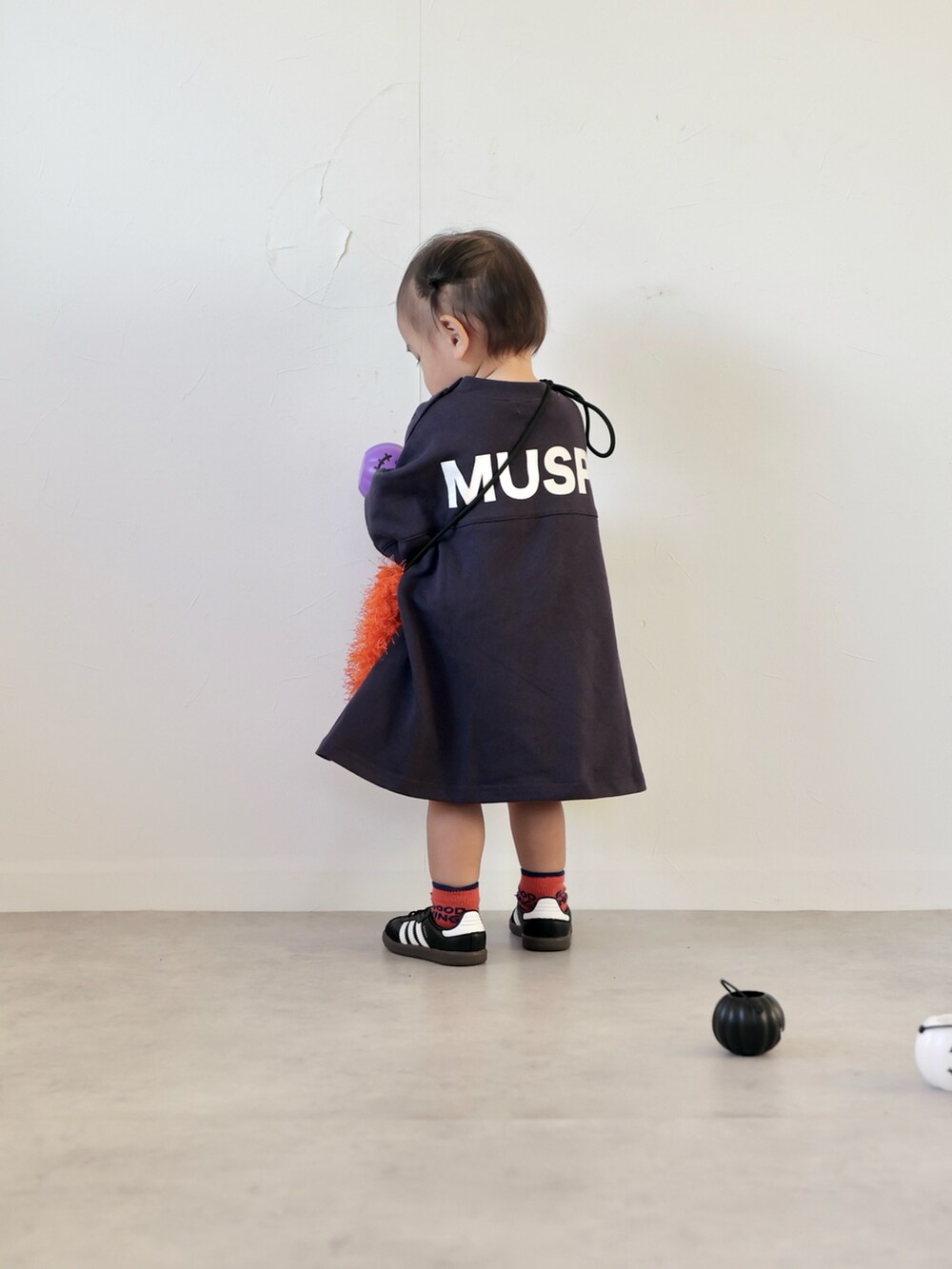 ブルー系のワンピース、オレンジ系のショルダーバッグ、ブラック系のスニーカーを着用したキッズの秋コーディネートの4枚目の写真