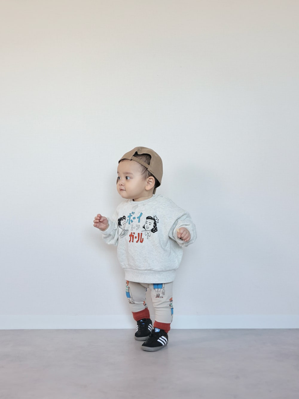 ホワイト系のスウェット、ブラック系のスニーカー、ホワイト系のレギンス/スパッツを着用したキッズの冬コーディネートの2枚目の写真