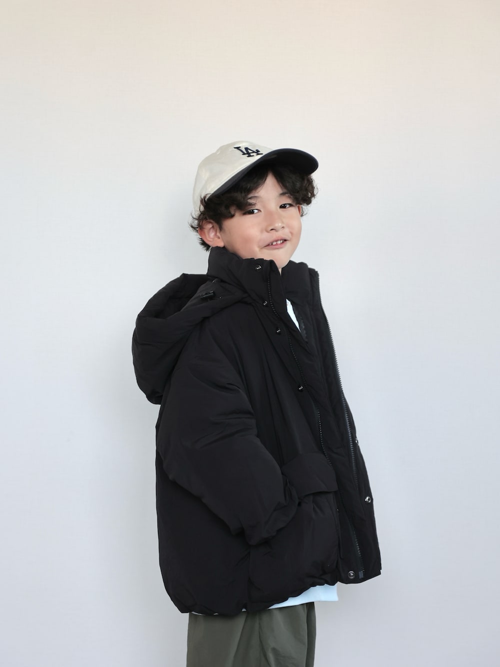 グリーン系のその他パンツ、ブルー系のスウェット、ブラック系のダウンジャケット/コートを着用したキッズの秋コーディネートの5枚目の写真