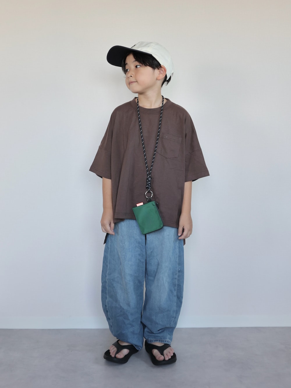 ブラウン系のTシャツ/カットソー、ブラック系のサンダル、グレー系のスウェットパンツを着用したキッズの夏コーディネートの5枚目の写真