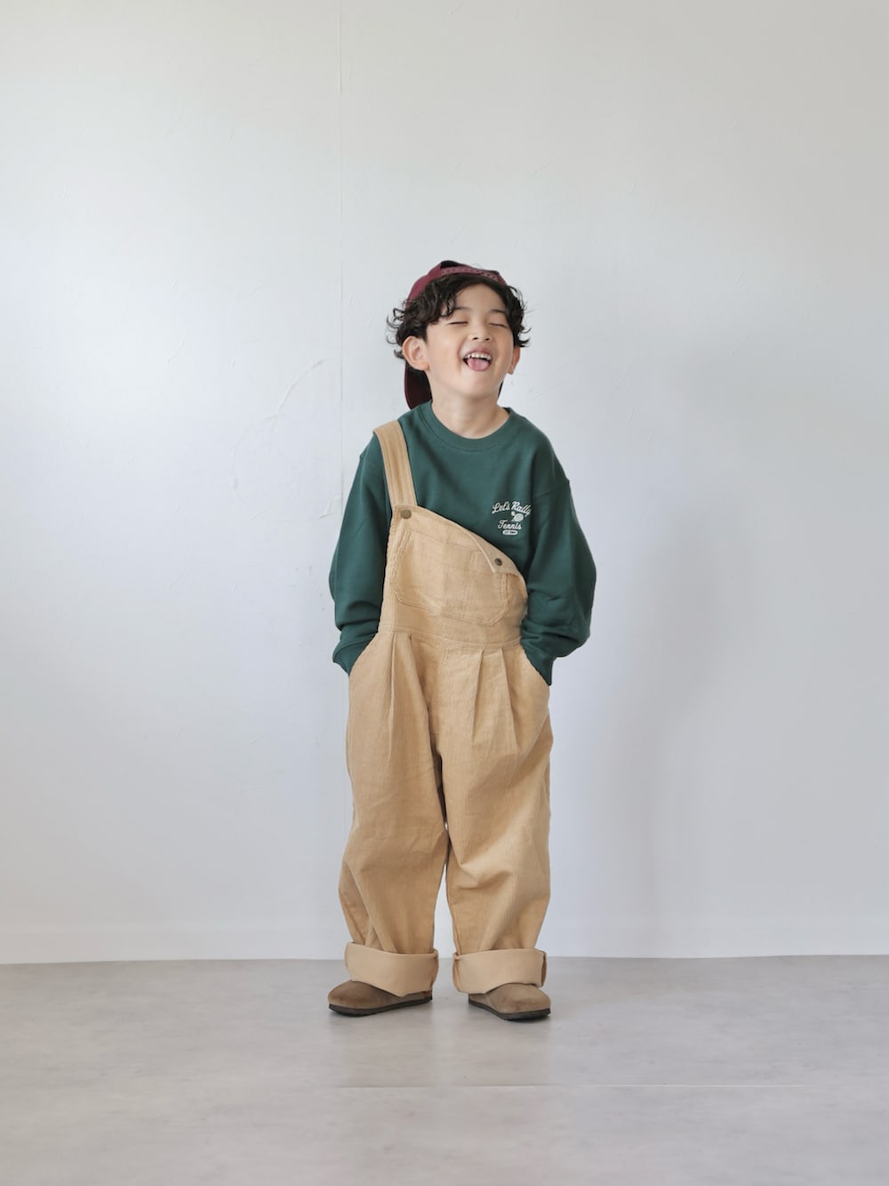 グリーン系のトップス、イエロー系のサロペット/オーバーオール、ベージュ系のシューズを着用したキッズの秋コーディネートの2枚目の写真