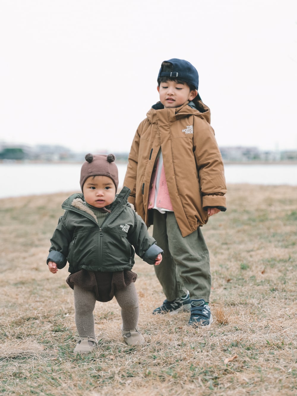 ブラウン系のその他アウター、グリーン系のカーゴパンツ、ブルー系のスニーカーを着用したキッズの冬コーディネートの3枚目の写真