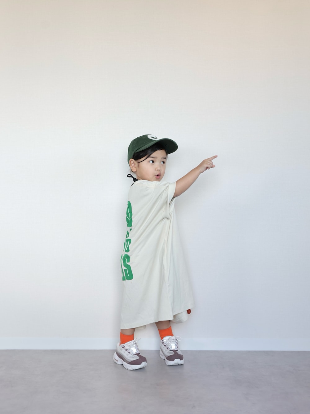 ホワイト系のTシャツ/カットソー、オレンジ系のショルダーバッグ、ホワイト系のスニーカーを着用したキッズの春コーディネートの5枚目の写真