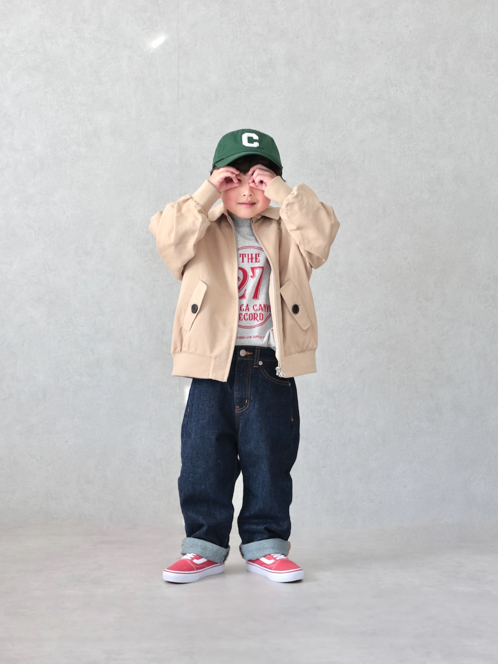 ブラウン系のブルゾン、グレー系のTシャツ/カットソー、ブルー系のデニムパンツを着用したキッズの春コーディネートの2枚目の写真