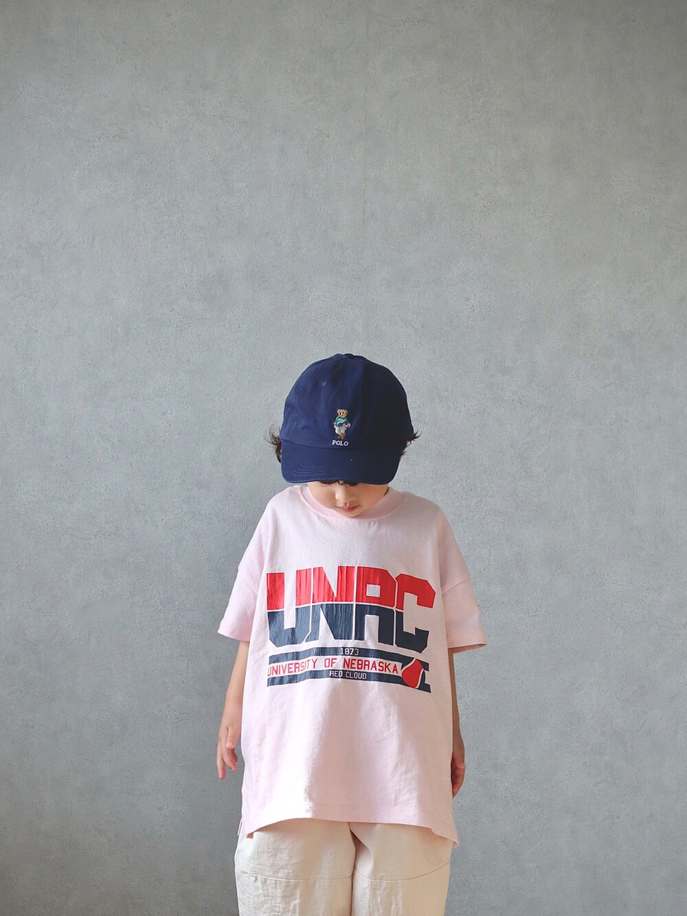 ブラック系のステンカラーコート、ピンク系のTシャツ/カットソー、ホワイト系のその他パンツを着用したキッズの春コーディネートの5枚目の写真