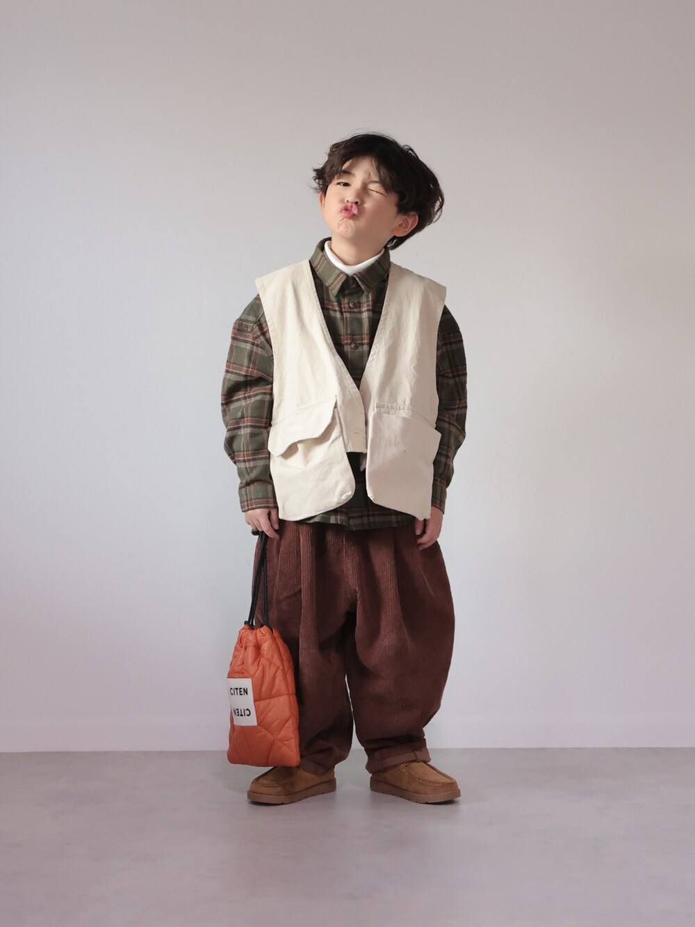 グリーン系のシャツ/ブラウス、ホワイト系のベスト、ホワイト系のTシャツ/カットソーを着用したキッズの冬コーディネートの4枚目の写真