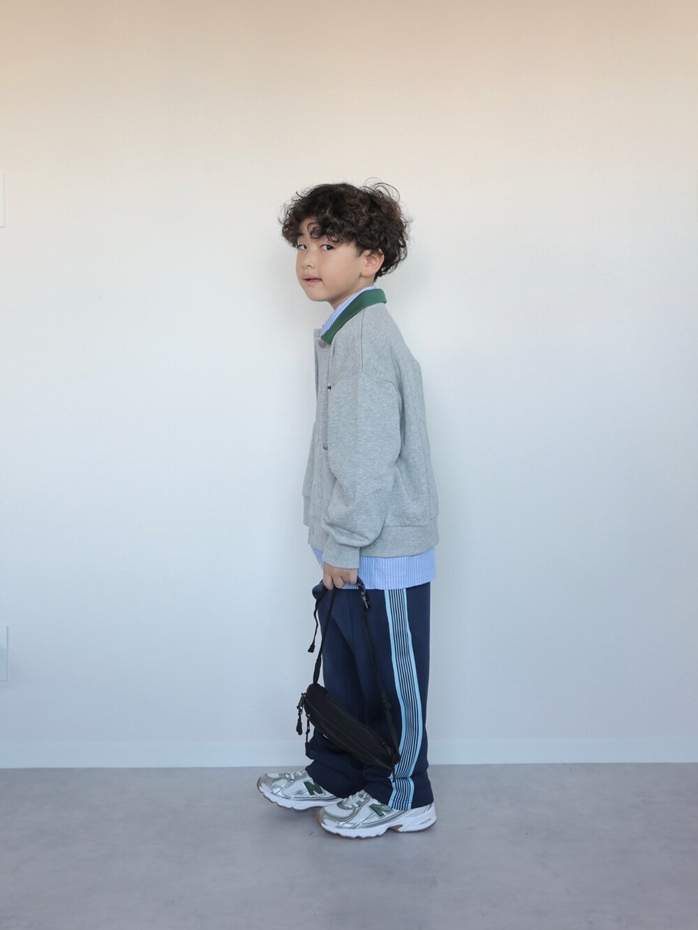 グレー系のカーディガン/ボレロ、ブルー系のシャツ/ブラウス、ブルー系のスウェットパンツを着用したキッズの秋コーディネートの2枚目の写真