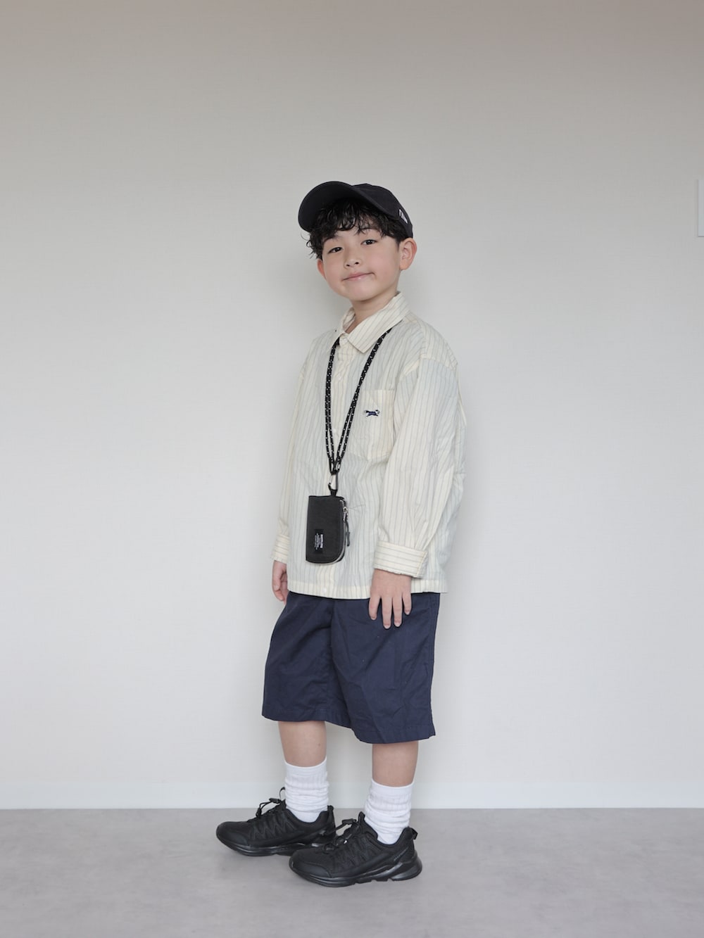 イエロー系のシャツ/ブラウス、ブラック系のスニーカー、ブルー系のパンツを着用したキッズの春コーディネートの4枚目の写真