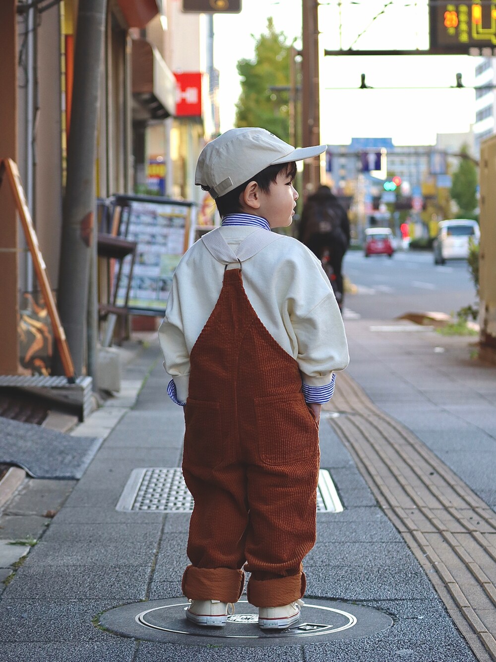 ホワイト系のスウェット、ブルー系のシャツ/ブラウス、イエロー系のサロペット/オーバーオールを着用したキッズの秋コーディネートの5枚目の写真