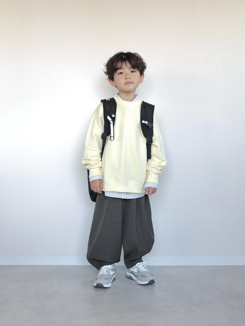 イエロー系のトップス、ホワイト系のシャツ/ブラウス、グレー系のその他パンツを着用したキッズの春コーディネートの4枚目の写真