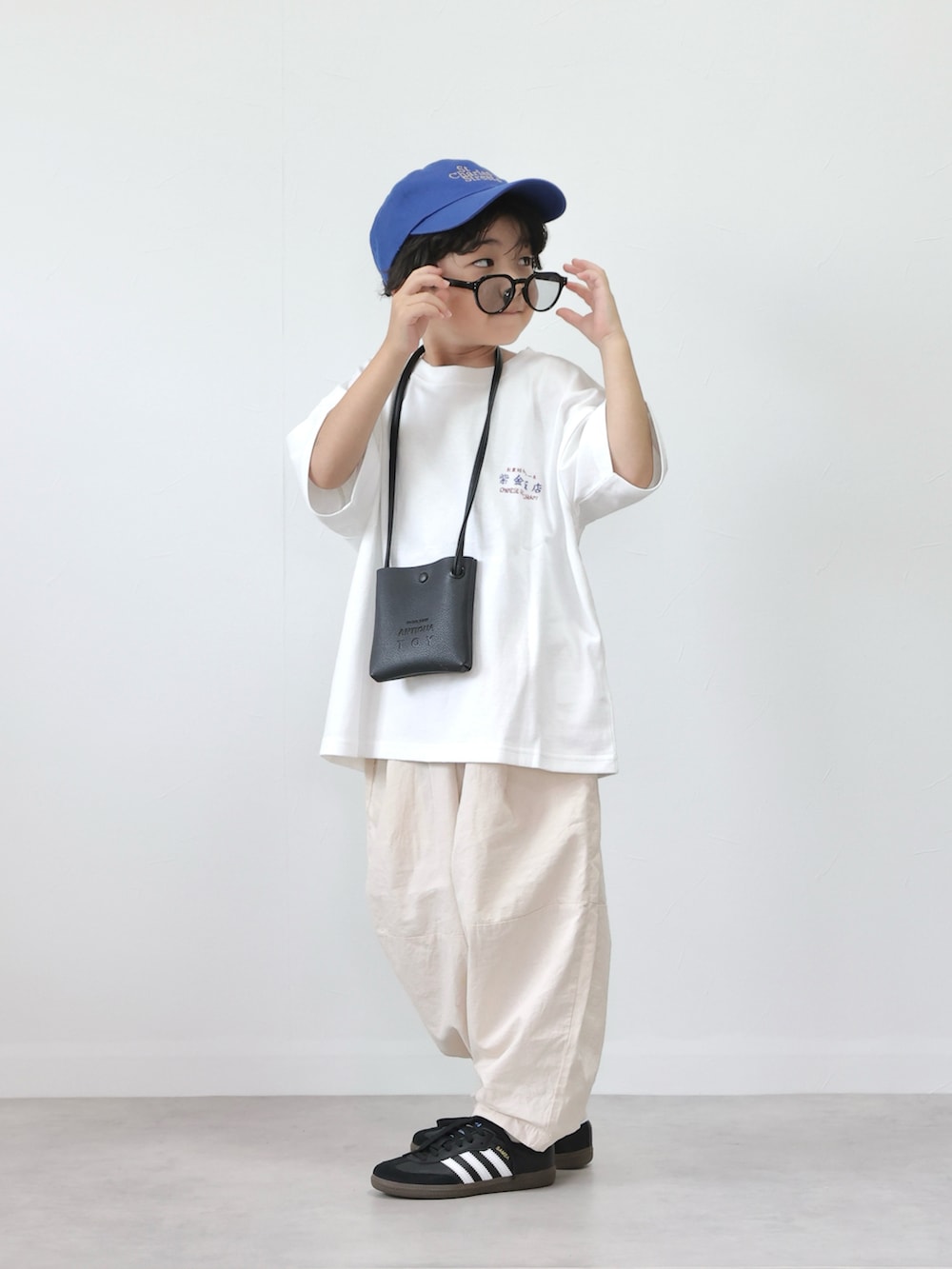 ホワイト系のTシャツ/カットソー、ホワイト系のその他パンツ、ブラック系のスニーカーを着用したキッズの夏コーディネートの2枚目の写真