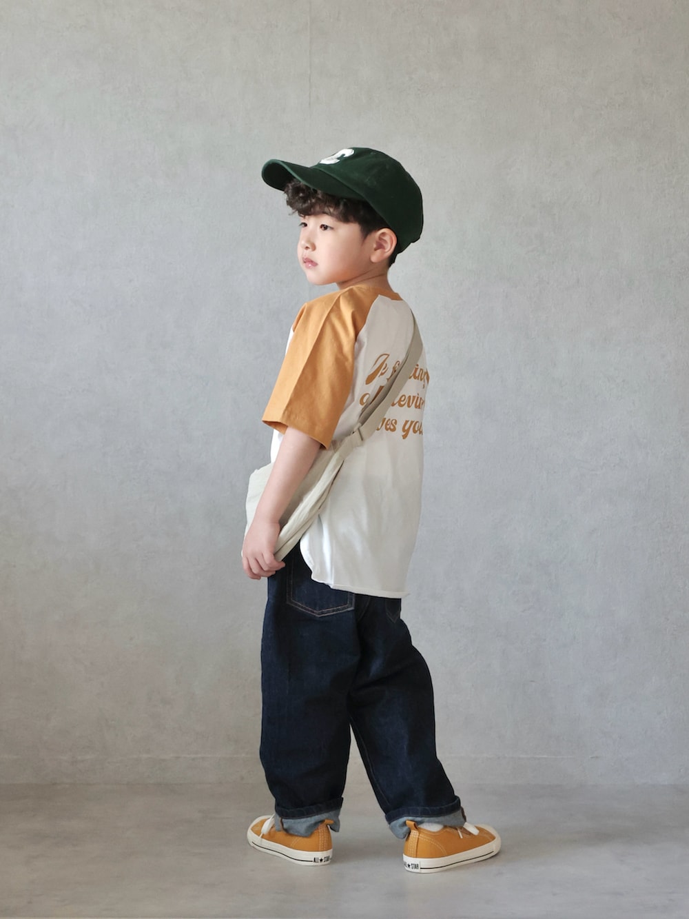 イエロー系のTシャツ/カットソー、ブルー系のデニムパンツ、イエロー系のスニーカーを着用したキッズの春コーディネートの2枚目の写真