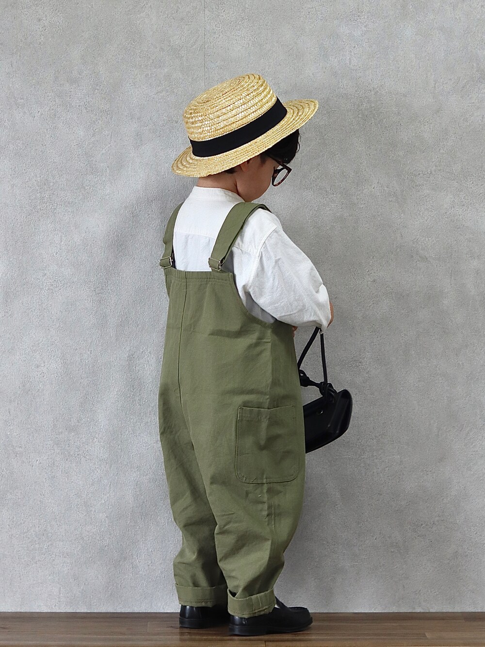 グリーン系のサロペット/オーバーオール、ホワイト系のシャツ/ブラウス、ブラック系のローファーを着用したキッズの春コーディネートの4枚目の写真