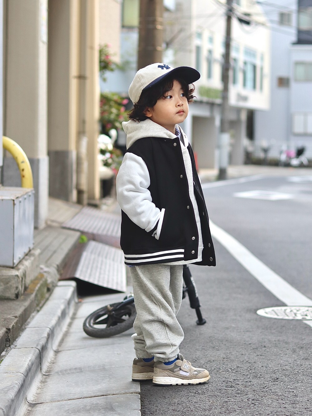 ブラック系のスタジャン、ホワイト系のパーカー、ホワイト系のスウェットパンツを着用したキッズの冬コーディネートの2枚目の写真