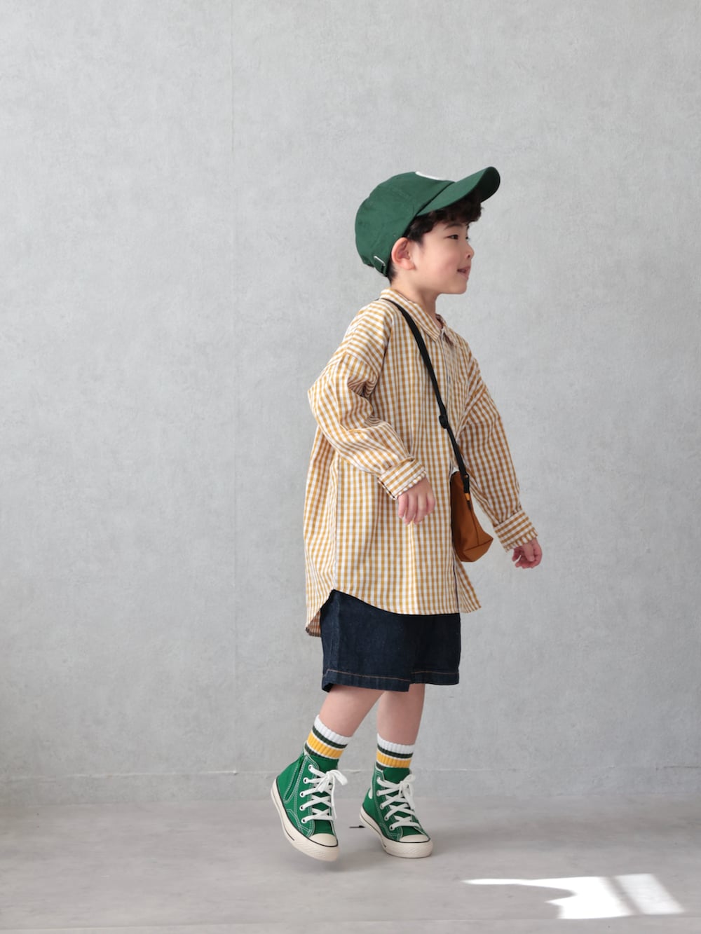 イエロー系のシャツ/ブラウス、ブルー系のデニムパンツ、グリーン系のスニーカーを着用したキッズの春コーディネートの2枚目の写真