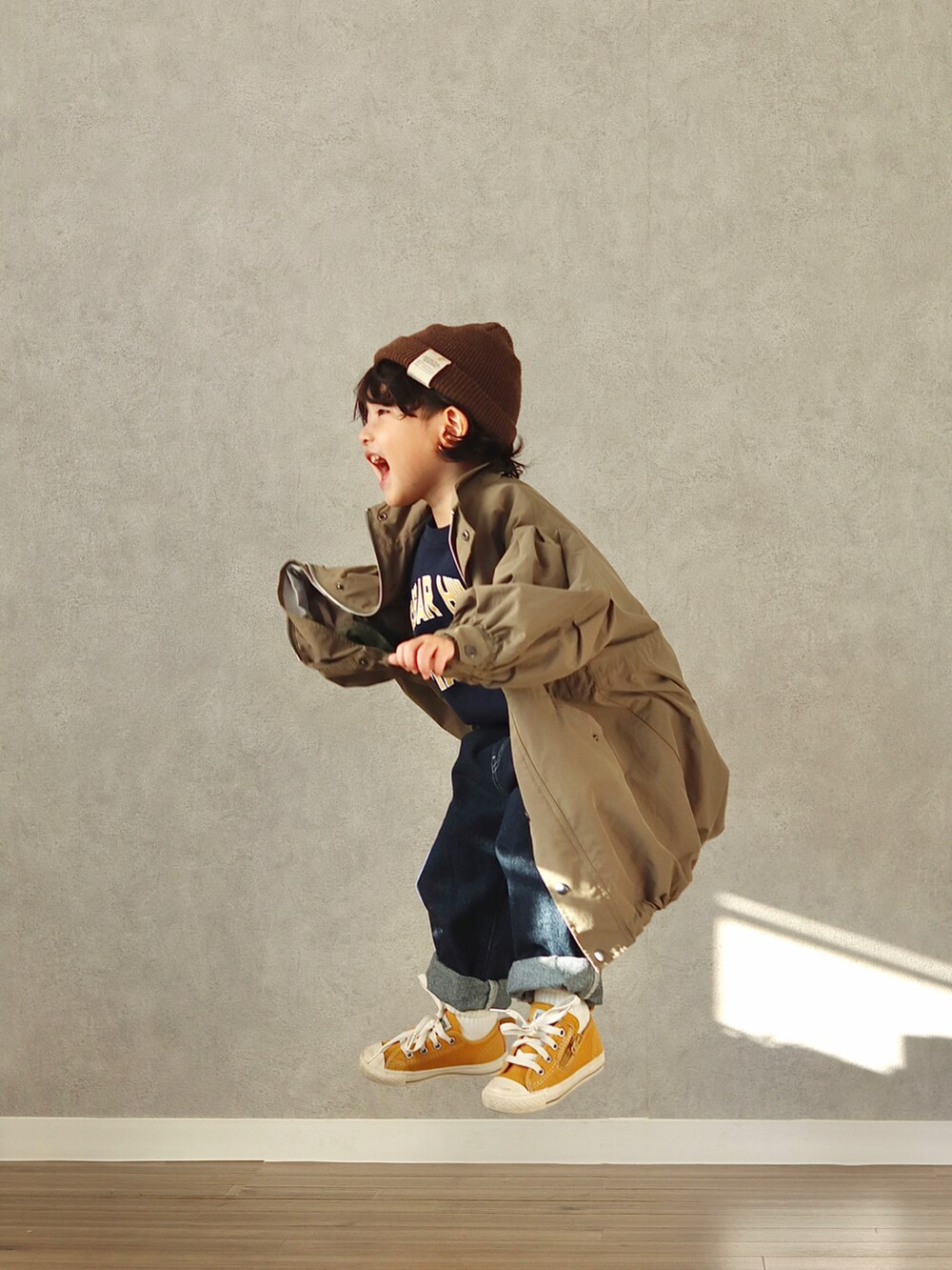 グリーン系のモッズコート、ブルー系のスウェット、ブルー系のデニムパンツを着用したキッズの冬コーディネートの2枚目の写真