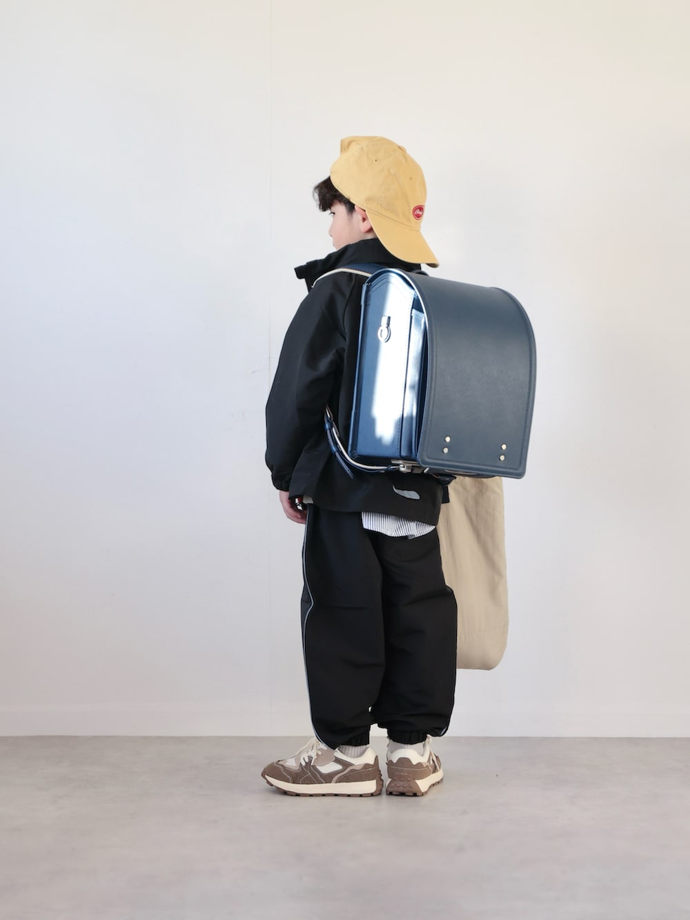 ブラック系のマウンテンパーカー、ブラック系のその他パンツ、グレー系のスウェットを着用したキッズの冬コーディネートの3枚目の写真