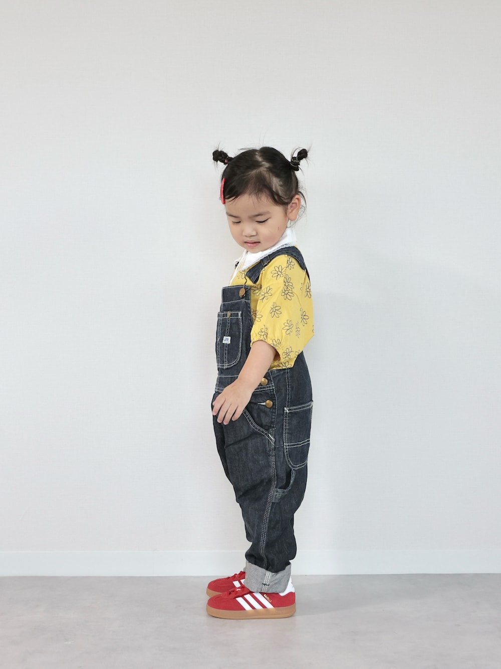 レッド系のスニーカー、イエロー系のTシャツ/カットソー、ブルー系のサロペット/オーバーオールを着用したキッズの夏コーディネートの2枚目の写真